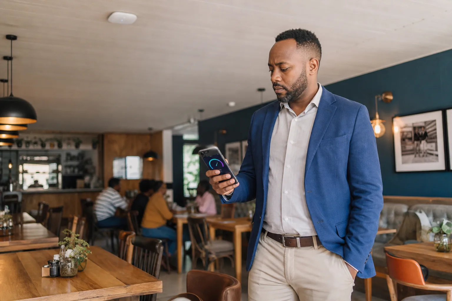 Restaurant manager checking venue WiFi performance beneath a ceiling-mounted access point